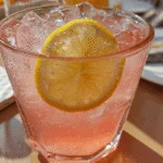 pink salt trick detox drink in a glass with lemon