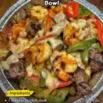 Cheesy Steak & Shrimp Skillet Bowl with colorful ingredients cooked in a cast iron pan