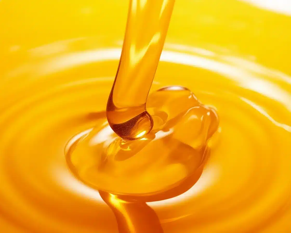 A jar of honey beside fresh lemon and ginger, showcasing the Honey Trick Recipe ingredients.